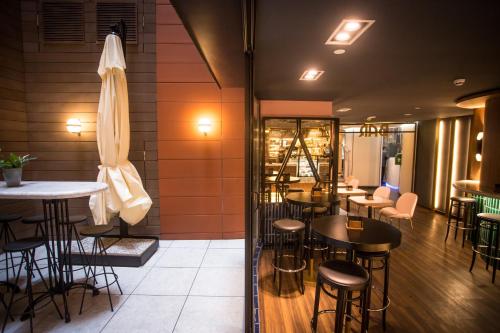 a restaurant with tables and chairs and a umbrella at Hotel Indigo Madrid - Gran Vía by IHG in Madrid