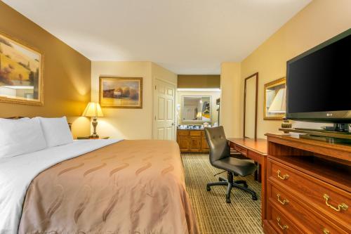 a hotel room with a bed and a desk with a television at Quality Inn Johnson City I-26 exit 17 in Johnson City