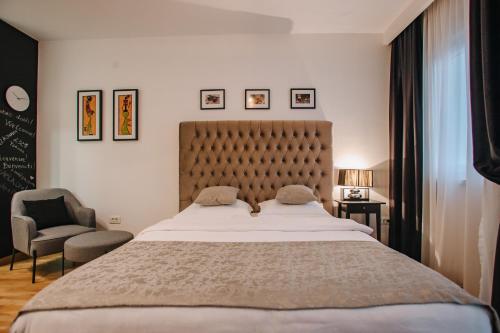 1 dormitorio con 1 cama grande y 1 silla en Apartments Doclea en Podgorica