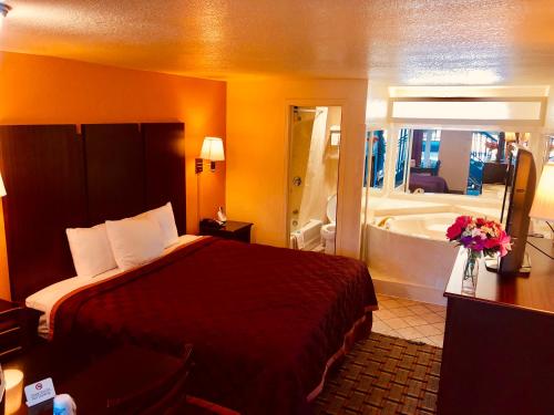 HopeにあるAmericas Best Value Inn and Suites Hopeのベッドとバスタブ付きのホテルルームです。