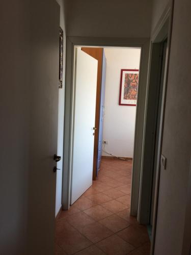a hallway with two white doors and a tile floor at Airport-FREE shuttle till Night-BIG POOL-air cond-wi fi- sheets&linen wash machine ALL INCLUDED IN PRICE in Olbia