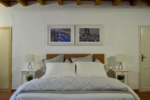 a bedroom with a bed with two pictures on the wall at Dante's Relais in Florence