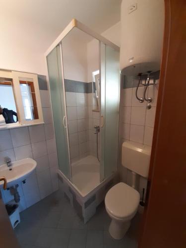 a bathroom with a shower and a toilet and a sink at House Vida Goraleks in Baška Voda