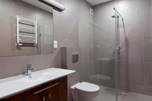 ein Bad mit einer Dusche, einem WC und einem Waschbecken in der Unterkunft Apartamenty Mesa Grill Restaurant Cafe in Dźwirzyno