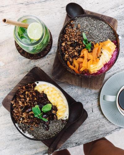 a table with three plates of food and a drink at Flowers & Fire Yoga Garden in Gili Air