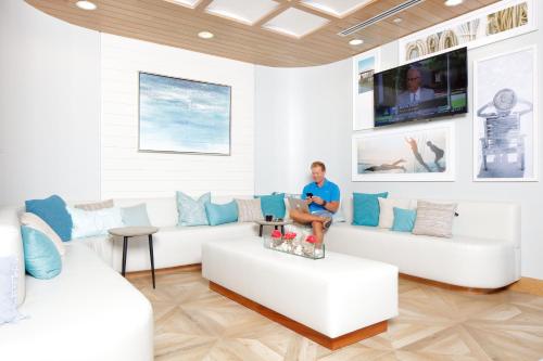 a woman sitting on a couch in a living room at Hotel Indigo Orange Beach - Gulf Shores by IHG in Gulf Shores