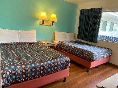 a hotel room with two beds and a window at Vagabond Inn Sylmar in Sylmar