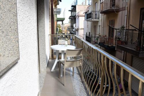 a balcony with a white table and chairs on it at IN CENTRO ROOMS Vicino Cefalù SELF-CHEK-IN in Campofelice di Roccella