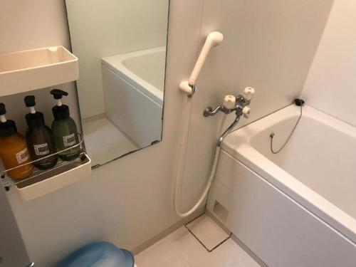 ein Badezimmer mit einem Waschbecken und eine Tür mit Weinflaschen in der Unterkunft Weekly Harbourview Mansion Main Building / Vacation STAY 76120 in Naha