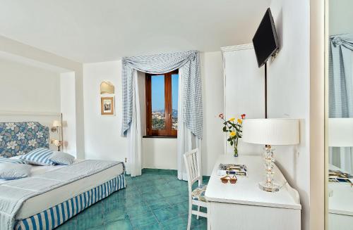 a bedroom with a bed and a table with a lamp at Villa Maria in Amalfi