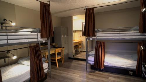 a room with three bunk beds and a desk at Banff International Hostel in Banff