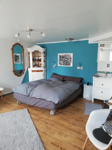 1 dormitorio con 1 cama con pared azul en fewoflagmeier Kohlstetten I Alte Backstube en Kohlstetten