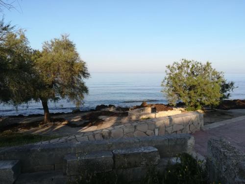 Lido ConchigliaにあるLa Maison de Gabrielèの背景の木と海を背景にした塀