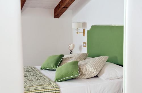 a bed with green and white pillows on it at Villa Maria in Amalfi