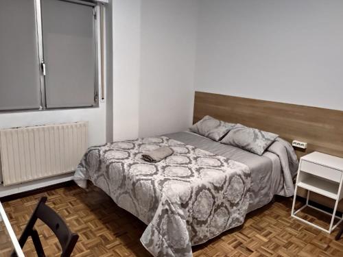 a small bedroom with a bed and a window at Apartamento Cigüeña in Logroño