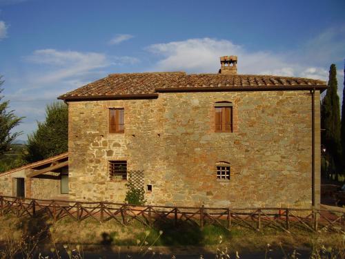 an old stone house with a fence in front of it at Podere Pievina Delle Corti - Dimora di Campagna in Sinalunga