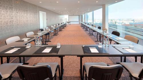 a row of tables in a room with chairs at Radisson Blu Hotel, Bruges in Bruges