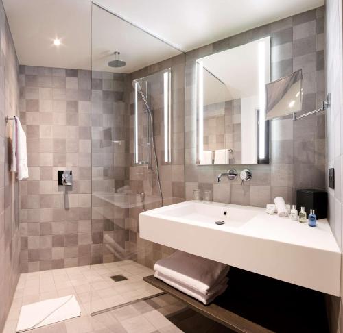 a bathroom with a sink and a shower at Radisson Blu Hotel, Bruges in Bruges