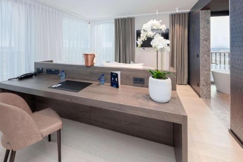 a bathroom with a desk with a sink and a tub at Radisson Blu Hotel, Bruges in Bruges