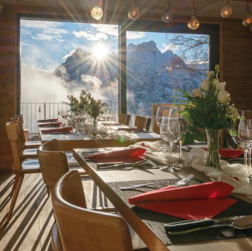 a dining room with a table with a view of the mountain at Berggasthaus Eggberge - Boutique Mountain Hotel - Access via Cablecar in Altdorf