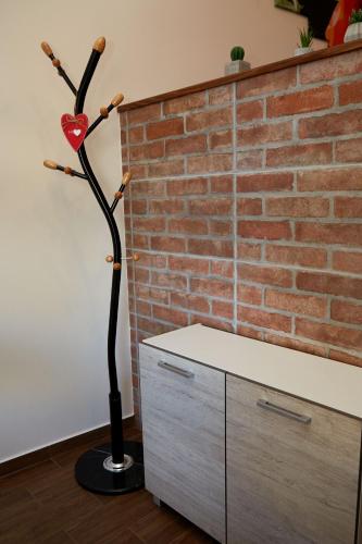 a red heart on a stick in front of a brick wall at Apartman Biskupice in Fiľakovo