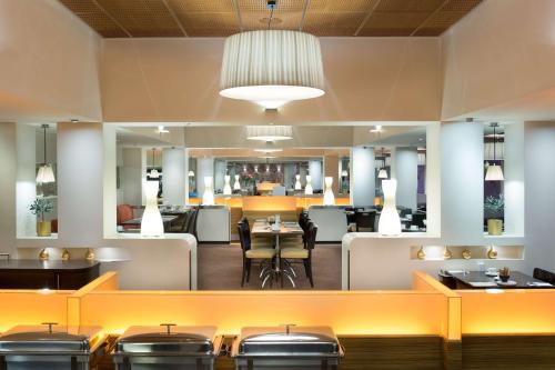 a restaurant with tables and chairs and a bar at Radisson Blu Hotel Olümpia in Tallinn