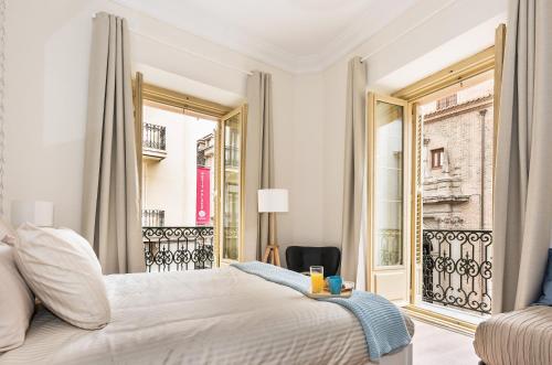 een slaapkamer met een bed en een groot raam bij Apartamento en Puerta del Sol in Madrid