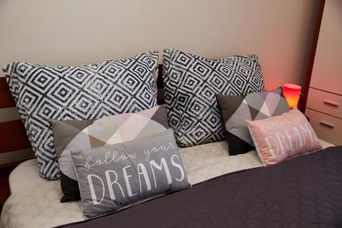 a bed with pillows on top of it at Apartman Biskupice in Fiľakovo
