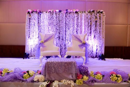 a purple and white wedding altar with two chairs and flowers at Radisson Blu Hotel, Abu Dhabi Yas Island in Abu Dhabi