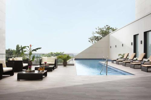 a hotel lobby with a pool and lounge chairs at Radisson Blu Lagos Ikeja in Lagos