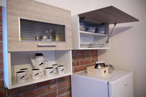 a kitchen with white cabinets and a white refrigerator at Apartman Biskupice in Fiľakovo