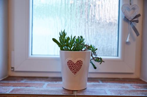 a vase with a heart on it sitting in front of a door at Apartman Biskupice in Fiľakovo