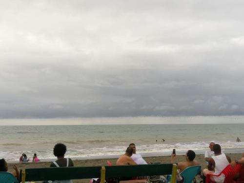 a group of people sitting on the beach at Hotel OBEGA PACIFIC in Nuquí