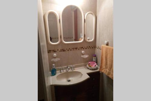 a bathroom with a sink and four mirrors at Casa&Pileta -#Postal de la Cordillera# Chacras de Coria - Vistalba in Mendoza