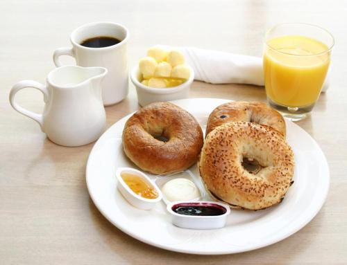 a plate with two donuts on a table with coffee and juice at B&B Vecchia Darsena in Augusta