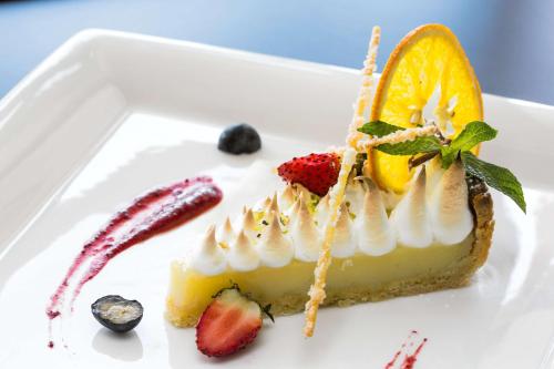 a piece of cheesecake with fruit on a white plate at Radisson Blu Hotel & Convention Centre Kigali in Kigali