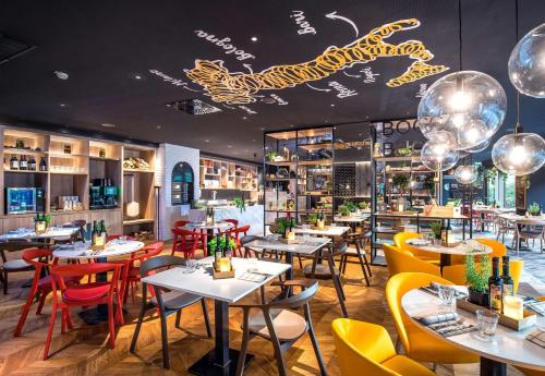 un restaurante con mesas, sillas y luces en Park Inn by Radisson Stuttgart en Stuttgart