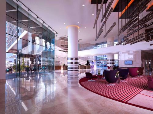 a lobby of a building with chairs and a red rug at Radisson Blu Hotel, Abu Dhabi Yas Island in Abu Dhabi