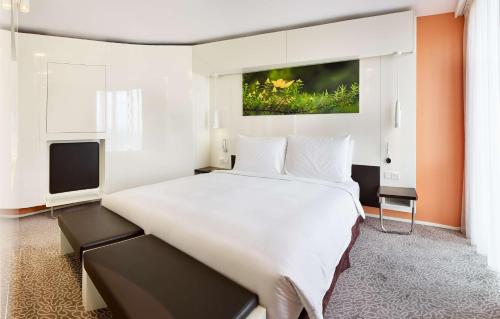 a bedroom with a large white bed and a tv at Radisson Blu Hotel & Convention Centre Kigali in Kigali