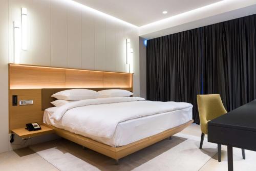 ein Schlafzimmer mit einem großen Bett und einem Schreibtisch in der Unterkunft Radisson Hotel Dakar Diamniadio in Dakar