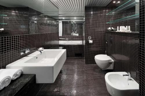 a black and white bathroom with a sink and a toilet at Radisson Blu Hotel Olümpia in Tallinn