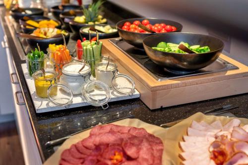 a buffet with plates of food and bowls of food at Park Inn by Radisson Nürnberg in Nuremberg