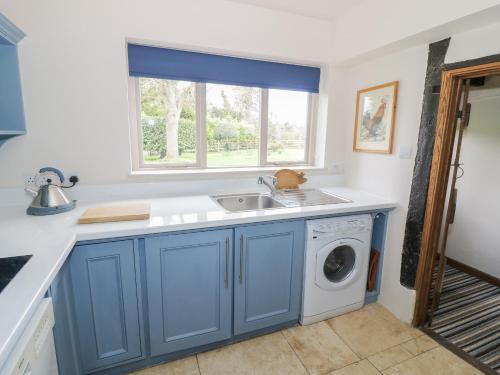 uma cozinha com um lavatório e uma máquina de lavar roupa em Bakehouse Farm em Princes Risborough