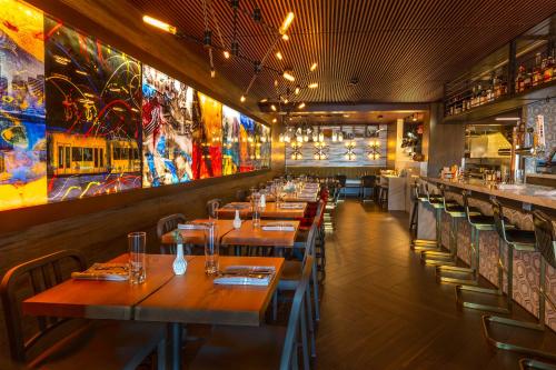 a restaurant with wooden tables and chairs and paintings on the walls at Silver Cloud Hotel - Portland in Portland