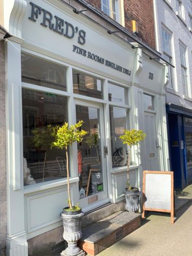 a store front with two potted trees outside of it at Upstairs at 33 - Self check in boutique accommodation in Worcester Centre in Worcester