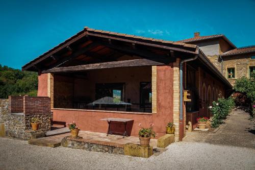 a building with a picnic table on a patio at Studio et colocation - Gîte Les 7 fontaines in Chevinay