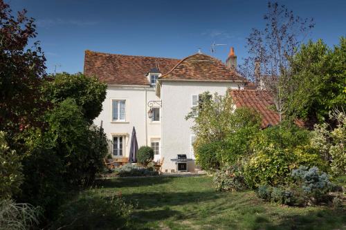 a large white house with a yard with bushes at La Bicyclette Bleue in Montmorillon