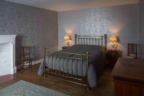 een slaapkamer met een bed en twee tafels en twee lampen bij La Bicyclette Bleue in Montmorillon