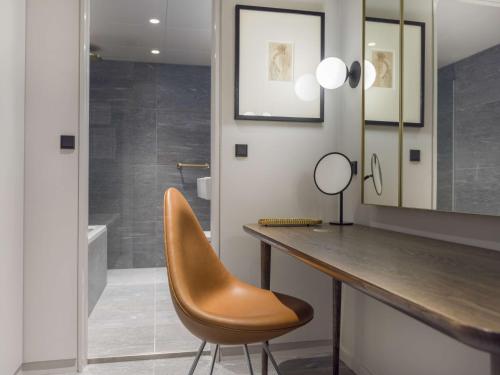 a bathroom with a desk and a chair and a mirror at Radisson Collection Royal Hotel, Copenhagen in Copenhagen