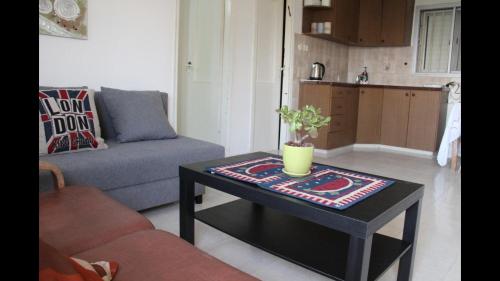 a living room with a table and a couch at Nazareth View in Naẕerat ‘Illit